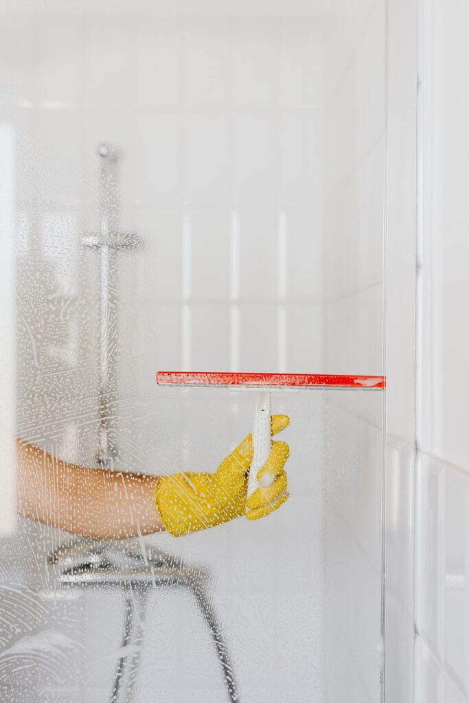 Person cleaning a window to remove cigarette smoke residue and yellow film